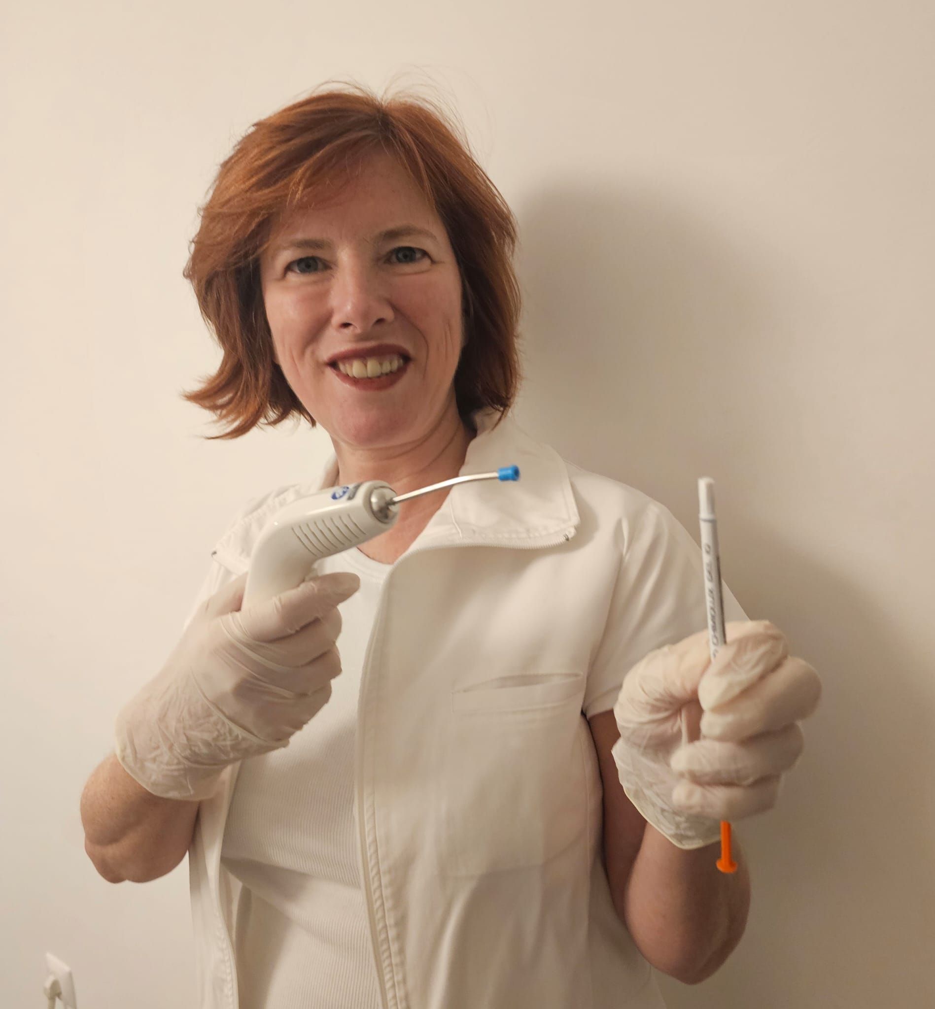 Mara Pedrero sorridente, com o equipamento de laser nas mãos